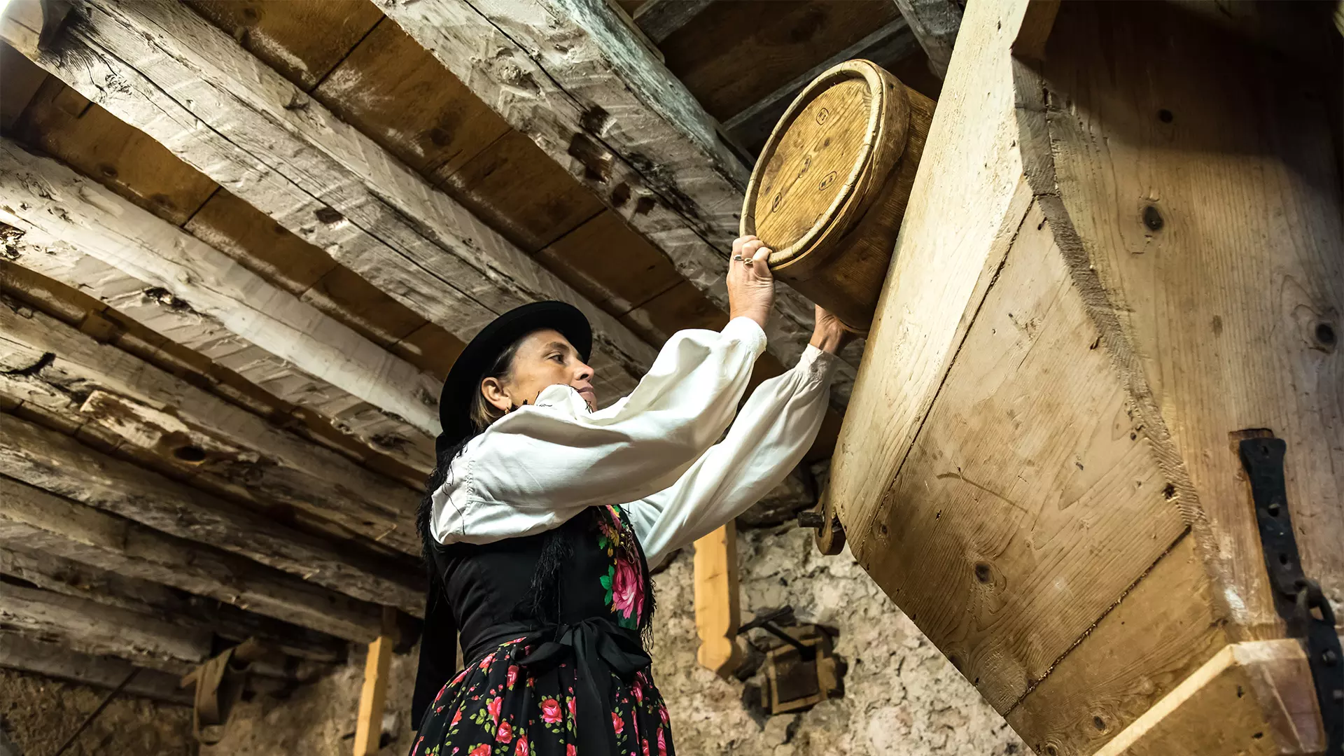 Donna in abiti tradizionali all'interno dell'antico mulino di Toffol, Val Fiorentina, Dolomitii (BL), Veneto, Italy